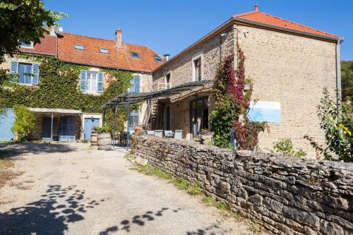 a building with a stone wall next to a street at Clos de belle roche in Saint-Romain