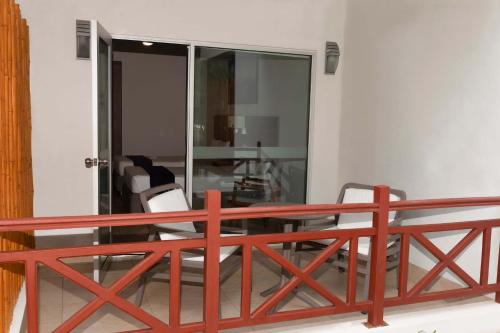 a balcony with a red railing and two chairs at Casa Andina Select Zorritos Tumbes in Zorritos
