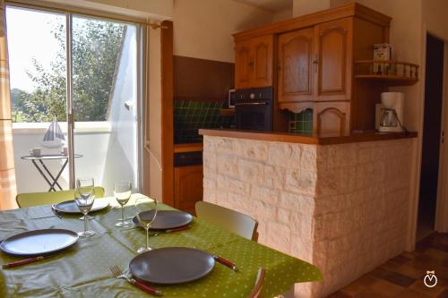 une cuisine avec une table avec des assiettes et des verres dans l'établissement Les portes de la mer, à Villers-sur-Mer