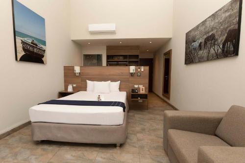 a bedroom with a large bed and a couch at Casa Andina Select Zorritos Tumbes in Zorritos