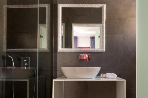 a bathroom with a sink and a mirror at MAR n MAR CROWN HOTEL-SUITES in Kamari