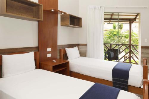 a hotel room with two beds and a window at Casa Andina Select Zorritos Tumbes in Zorritos