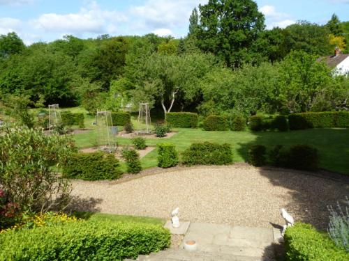um jardim com um parque com árvores e arbustos em Blackbrook House em Holmwood