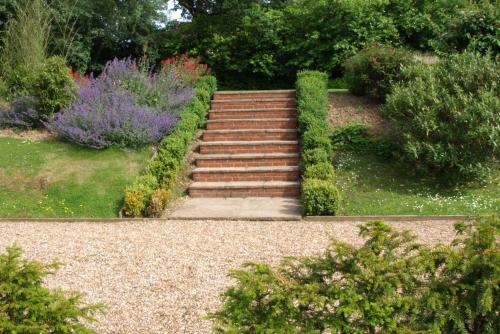 una rampa di scale in un giardino fiorito di Blackbrook House a Holmwood