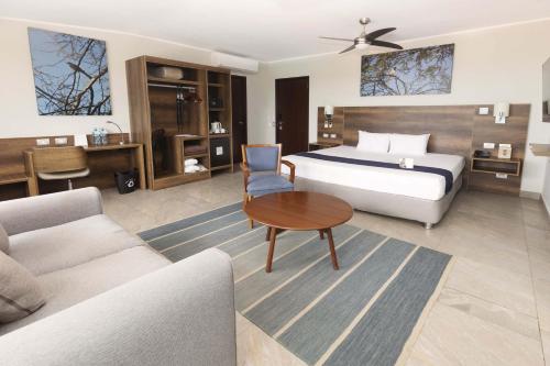 a bedroom with a bed and a table and a couch at Casa Andina Select Zorritos Tumbes in Zorritos