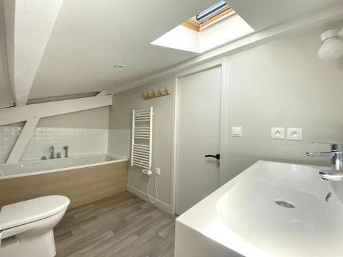 een badkamer met een wastafel, een toilet en een bad bij Agréable villa à Pyla plage in La Teste-de-Buch