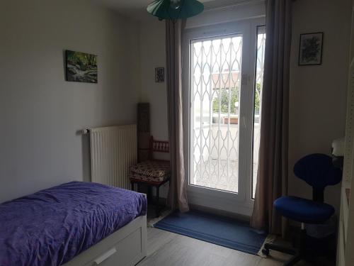 une chambre avec un lit et une porte coulissante en verre dans l'établissement Chambre privative avec terrasse, à Saint-Martin-dʼHères