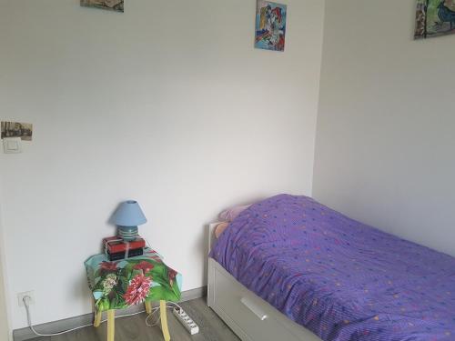 Dormitorio pequeño con cama y mesa en Chambre chez l'habitant, en Saint-Martin-dʼHères