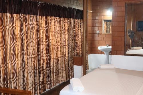 a bathroom with a shower curtain and a sink at spice garden Resorts munnar in Anachal