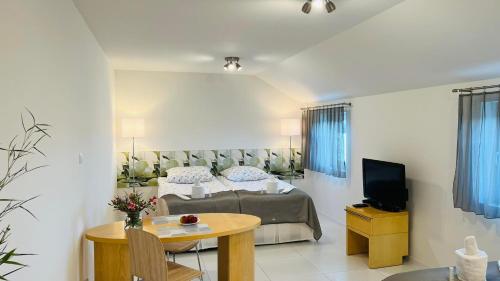 a bedroom with a bed and a table and a tv at AZYL in Legnica