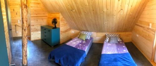 a room with two beds in a wooden cabin at Agroturystyka noclegi u Moniki domek drewniany in Oboźna Droga Masłów