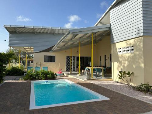 a house with a swimming pool in front of it at The Julianadorp Villas in Willemstad