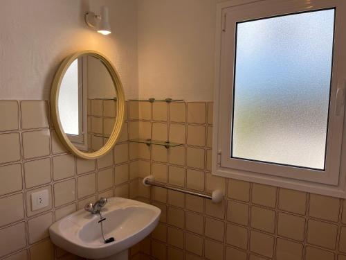 uma casa de banho com um lavatório e um espelho em MISTRAL 10 by SOM Menorca em Fornells
