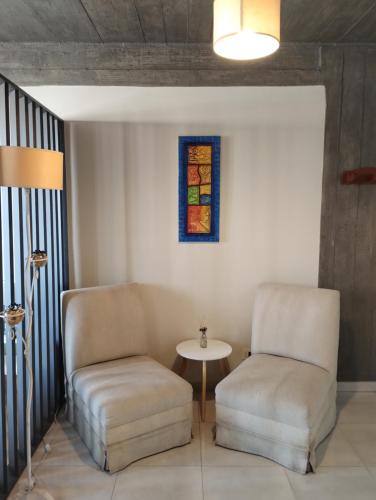 2 Stühle, ein Tisch und ein Buntglasfenster in der Unterkunft Jujuy 303 y Piedras in San Miguel de Tucumán