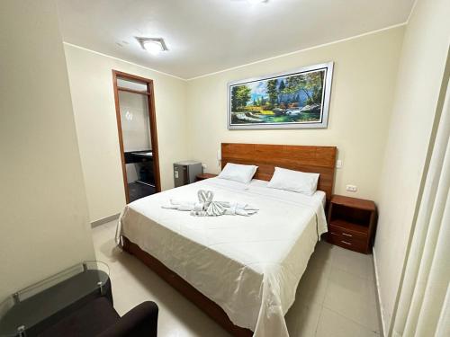 ein Schlafzimmer mit einem Bett mit einer weißen Tagesdecke in der Unterkunft HOTEL YHOMIL in Chincha Alta