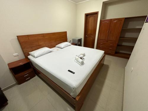 ein Schlafzimmer mit einem Bett und einem Telefon darauf in der Unterkunft HOTEL YHOMIL in Chincha Alta