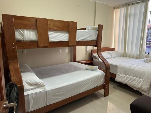 2 Etagenbetten in einem Zimmer mit Fenster in der Unterkunft HOTEL YHOMIL in Chincha Alta