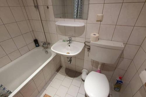 a bathroom with a toilet and a sink and a tub at Gemütliche Monteurwohnung in Sandersdorf bis 6 Personen in Sandersdorf