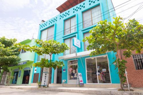 niebieski budynek na ulicy z drzewami przed w obiekcie Hotel Guivá Huatulco w mieście Santa Cruz Huatulco