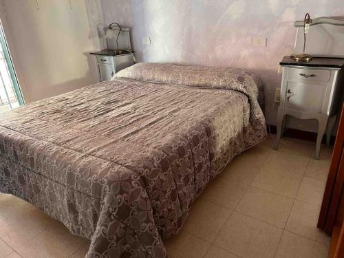 a small bedroom with a bed and a night stand at Casa Vale fronte mare in Ventimiglia