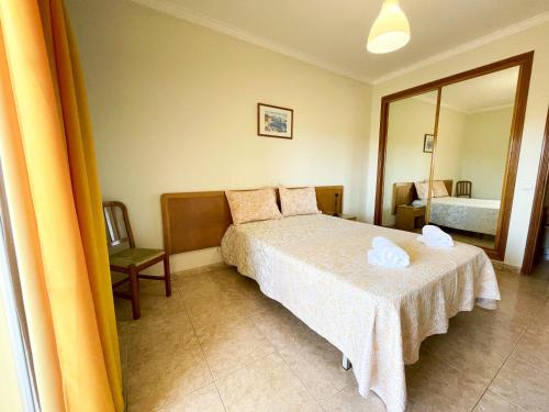 - une chambre avec un lit et un grand miroir dans l'établissement Apartamento T1 208, Praia do Vau - Terraços do Vau, à Portimão