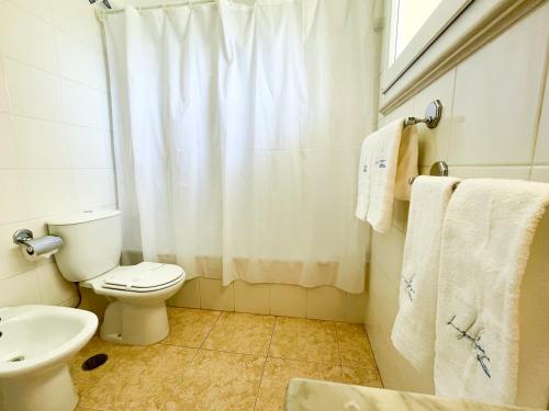 La salle de bains est pourvue de toilettes, d'un lavabo et d'une douche. dans l'établissement Apartamento T1 208, Praia do Vau - Terraços do Vau, à Portimão