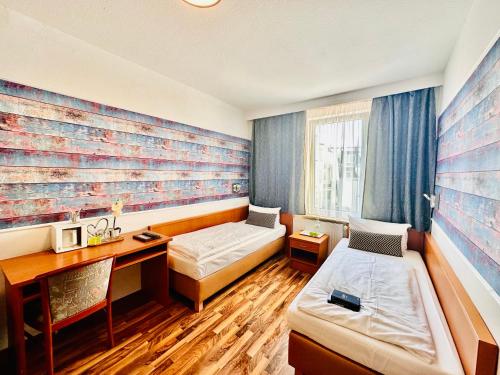 Zimmer mit 2 Betten und einem Schreibtisch. in der Unterkunft Hotel Condor in Hamburg