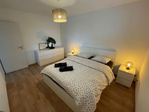 une chambre avec un grand lit et deux tables de nuit dans l'établissement Magnifique appartement à la frontière suisse, à Saint-Louis