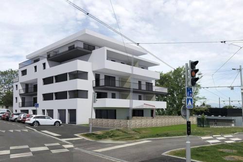 a white building with cars parked in front of it at Magnifique appartement à la frontière suisse in Saint-Louis