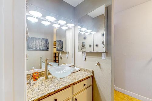 a bathroom with a sink and a large mirror at Main Street Retreat in Winter Park