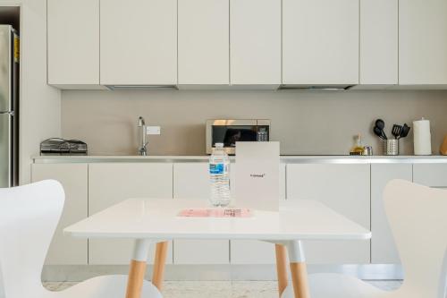 a white table in a kitchen with a bottle of water on it at La Moderna by Wynwood House in Panama City