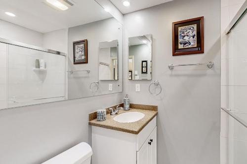 La salle de bains blanche est pourvue d'un lavabo et d'un miroir. dans l'établissement Bee Branch 13, à Sugar Mountain