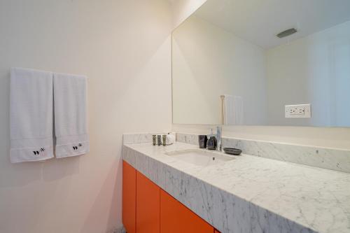 a white bathroom with a sink and a mirror at La Moderna by Wynwood House in Panama City