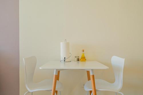 a table with white chairs and a candle on it at La Moderna by Wynwood House in Panama City