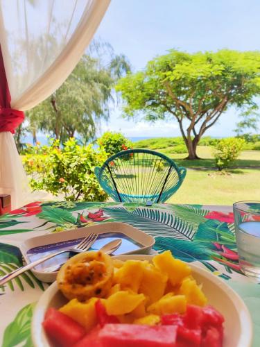 um prato de fruta numa mesa com uma toalha de mesa em Residence vacances : nature, mer, piscine et activités em Sainte-Anne