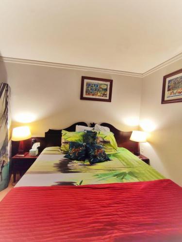 um quarto com uma cama grande e 2 candeeiros em Residence vacances : nature, mer, piscine et activités em Sainte-Anne