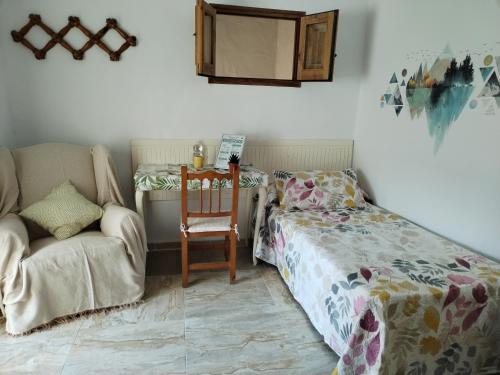 a bedroom with a bed and a chair and a couch at Apartamentos La Campana 5 in Jerez de la Frontera