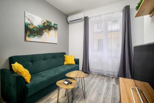 uma sala de estar com um sofá verde e uma janela em Golden Cage Premium Central Apartment em Budapeste