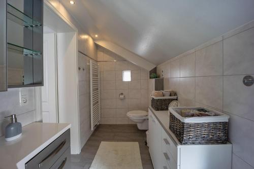 ein weißes Bad mit einem WC und einem Waschbecken in der Unterkunft Ferienwohnung Bloeck in Busdorf