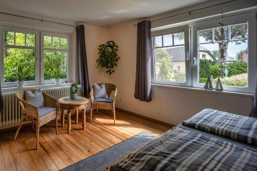 Schlafzimmer mit einem Bett, einem Tisch und Fenstern in der Unterkunft Ferienwohnung Bloeck in Busdorf