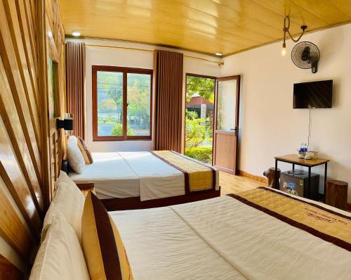 a hotel room with two beds and a television at Trang An Memory Homestay in Ninh Binh