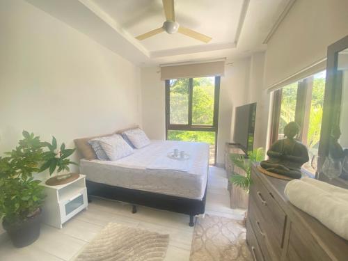 Schlafzimmer mit einem Bett und einem Deckenventilator in der Unterkunft Hacienda Iguana beach front Penthouse with swimming pools and ocean view in Tola