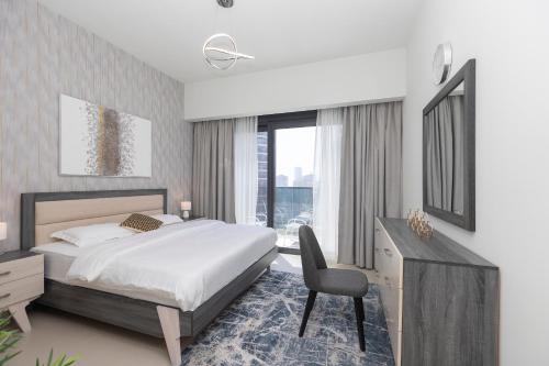 a bedroom with a bed and a desk and a chair at Elegant 2-BR Ritzy Retreat Steps from Burj Khalifa in Dubai