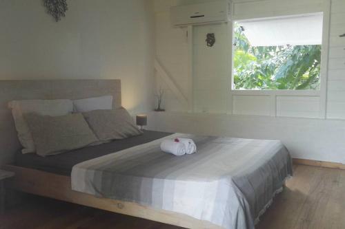 sypialnia z łóżkiem z ręcznikiem w obiekcie LE TIKI gîte côté canne w mieście Grand-Bourg