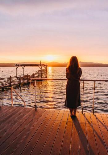 a woman standing on a pier looking at the water at Berzi Ferienwohnung 1 Görlitz in Görlitz