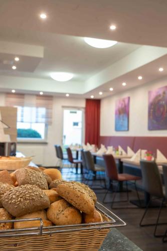 a basket of bread on a table in a restaurant at Hotel Am Freischütz in Hürth