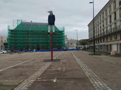 une statue d'un homme sur un poteau dans un parking dans l'établissement LA TERRASSE DE NOTRE DAME, au Havre