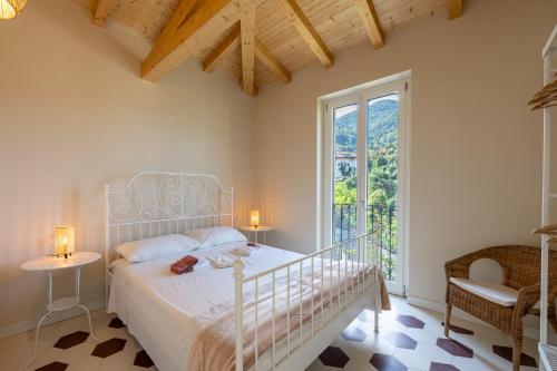 a bedroom with a white bed and a window at Villa Lilla Bellagio - Pool and Wine with Lake view in Bellagio
