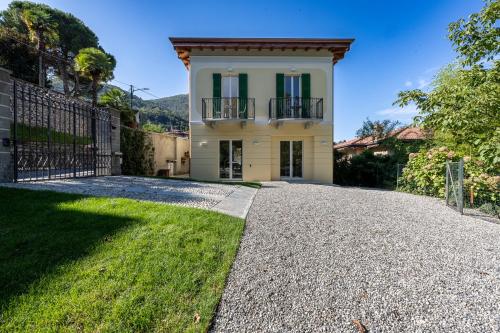 a house with a gate and a gravel driveway at Villa Lilla Bellagio - Luxury Pool and Wine with Lake view in Bellagio