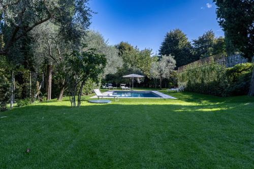 a yard with a swimming pool in the middle of it at Villa Lilla Bellagio - Luxury Pool and Wine with Lake view in Bellagio